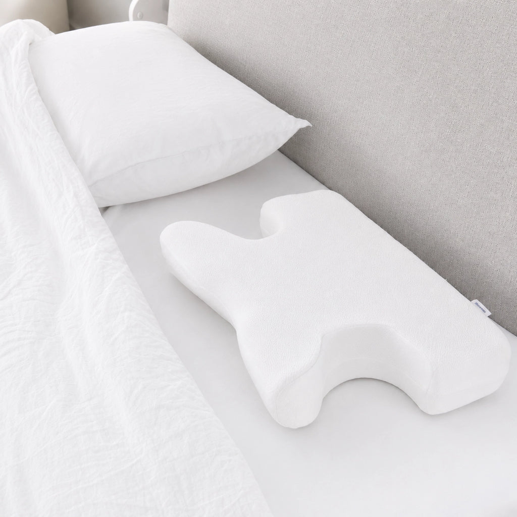 Advanced CPAP pillow with white cotton cover on a made bed